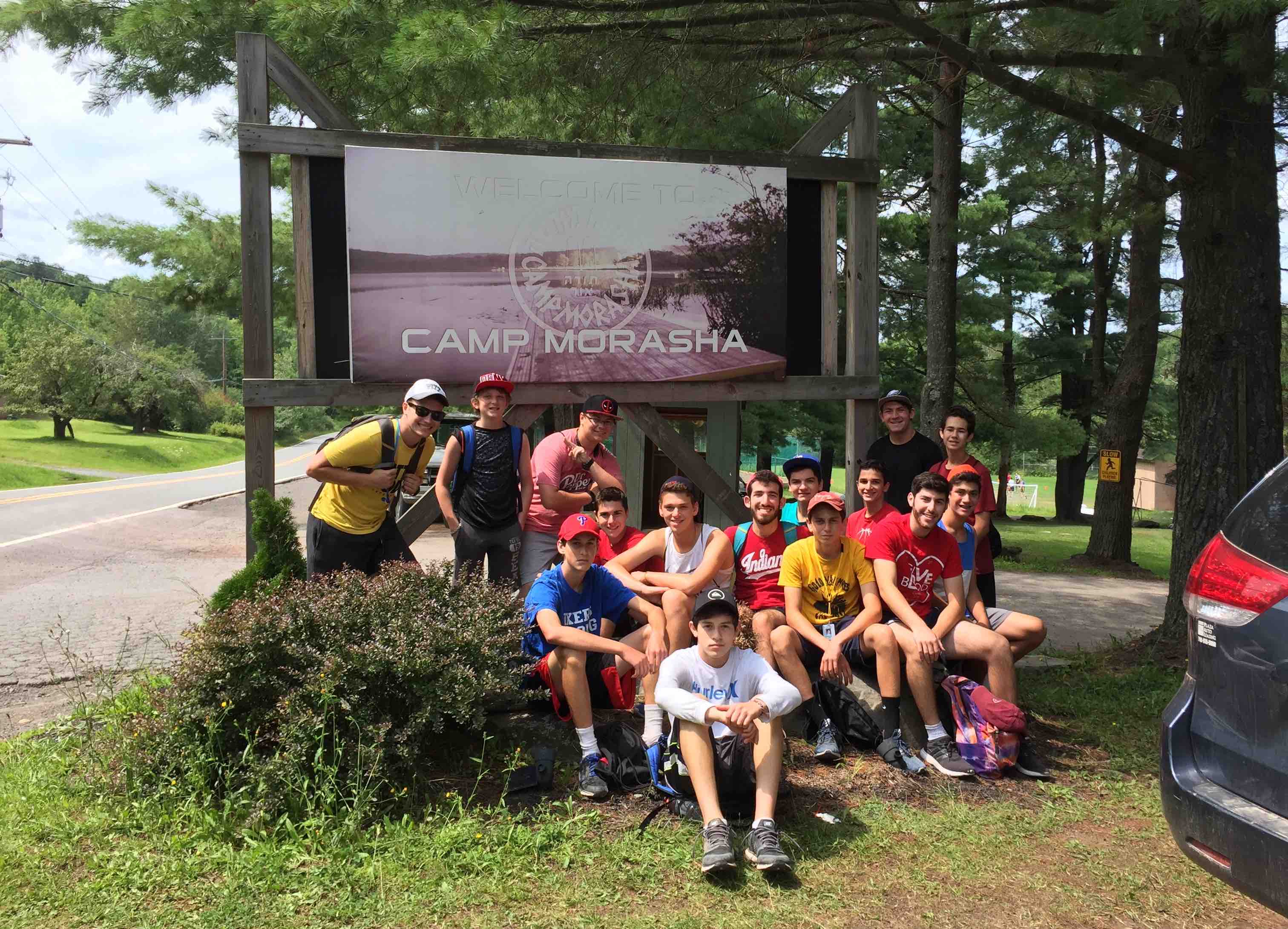 A group of boys in front of a sign "Camp Morasha"
