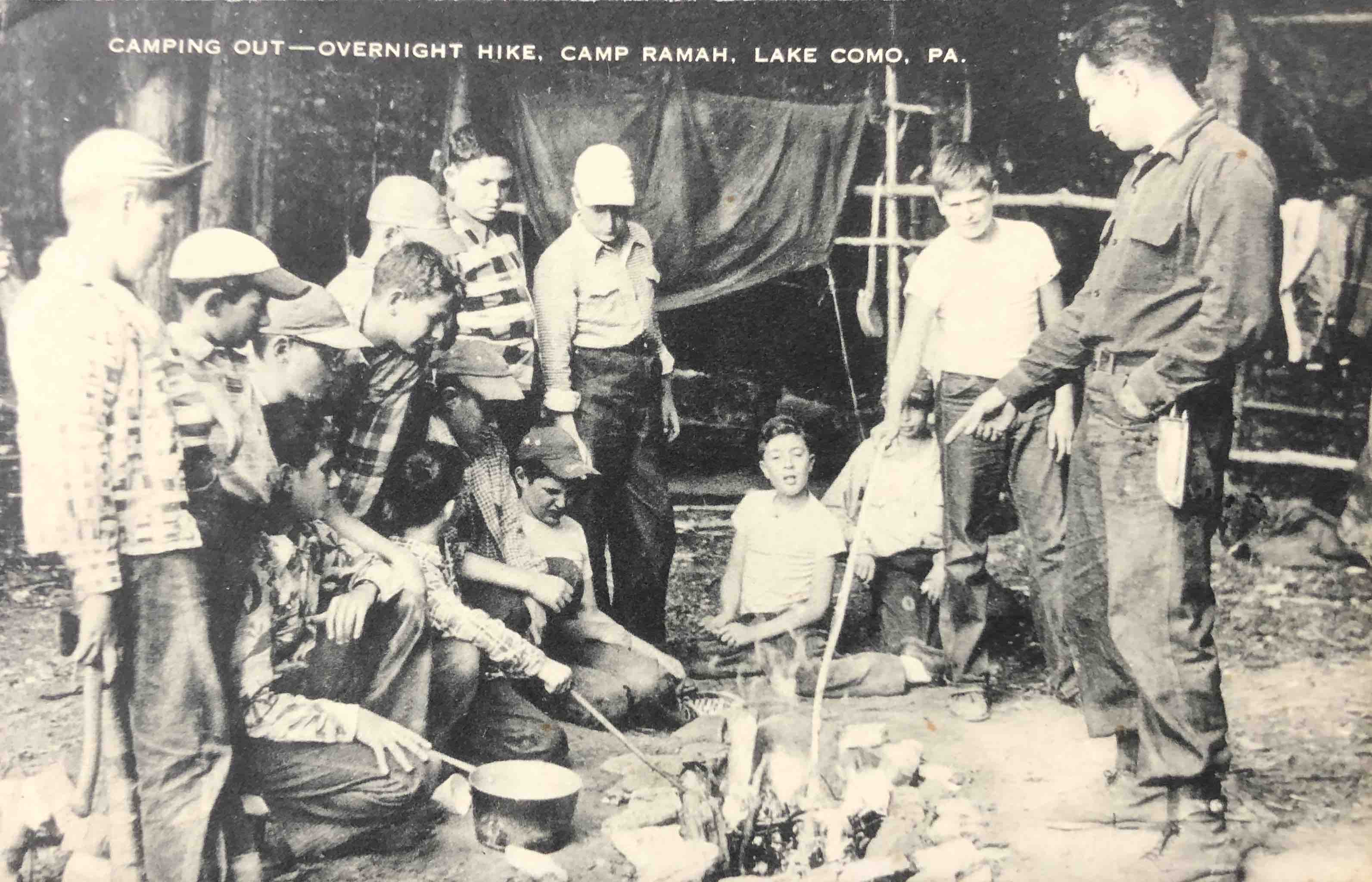 A postcard with a photograph of a people around a fire and the title "Camping Out — Overnight Hike, Camp Ramah, Lake Como, PA"