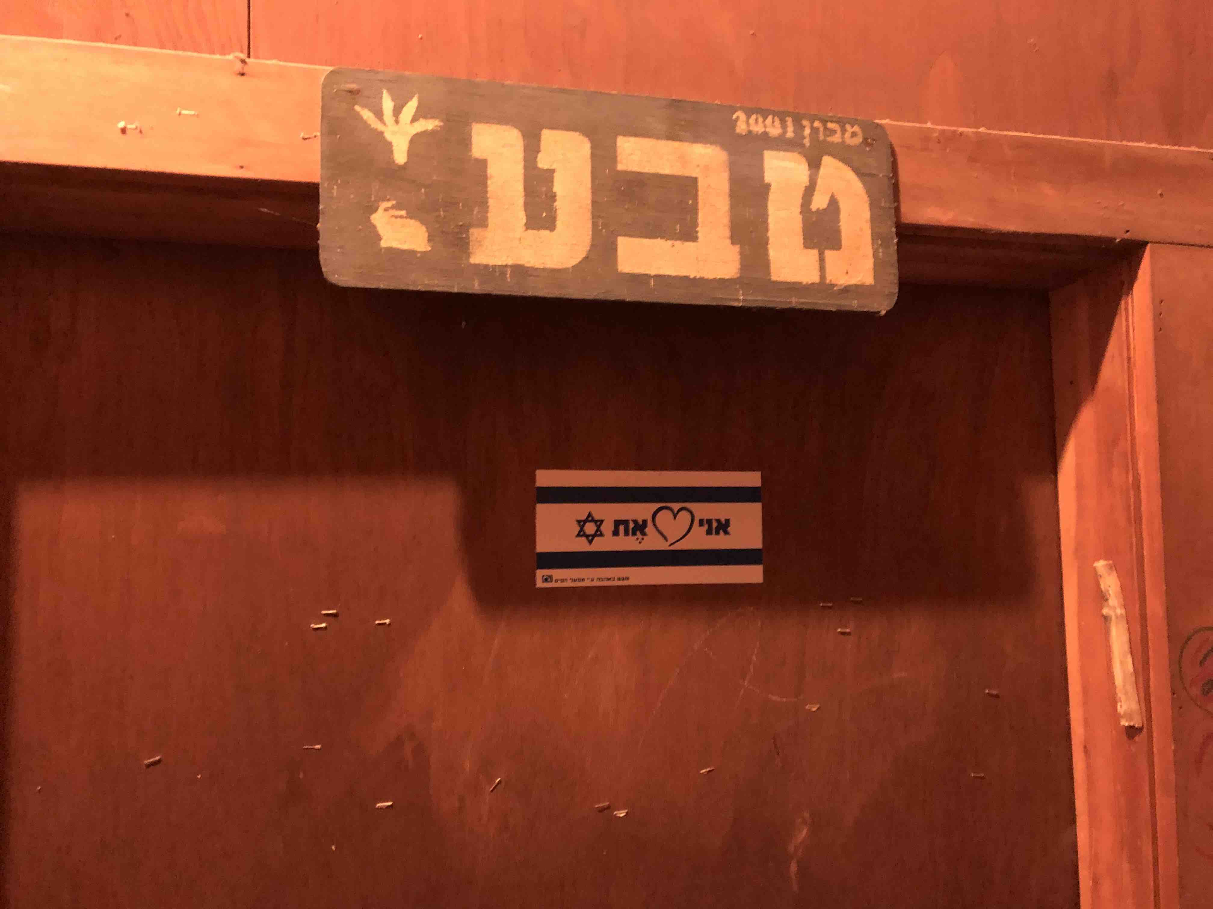 A photograph of a door with a sign "Teva" written in Hebrew